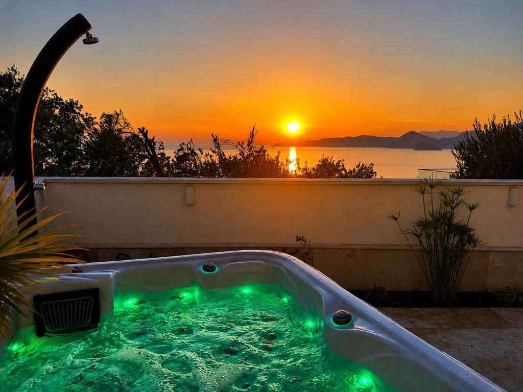 a hot tub with a sunset in the background at Sunset Vista Sonnenuntergang mit Jacuzzi und Sauna in Katun
