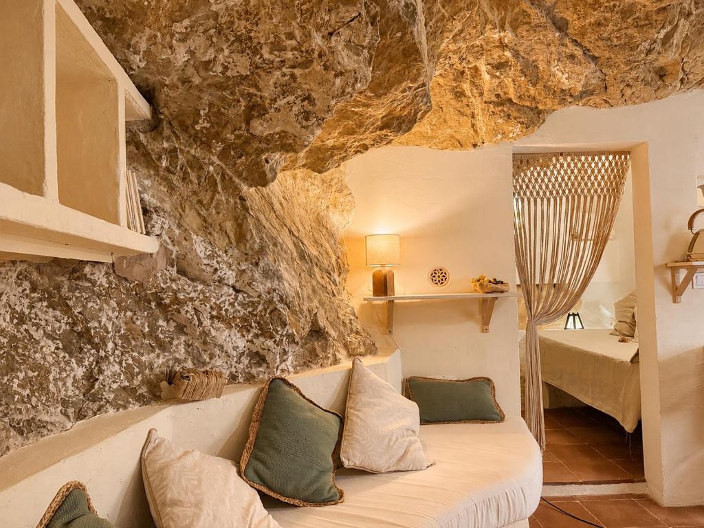 a living room with a couch and a rock wall at La Cueva De Orel in Molinicos