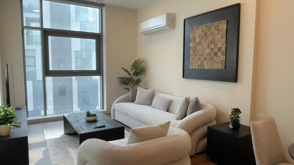 a living room with a couch and chairs and a table at Premium 2BHK Modern Design in Muscat