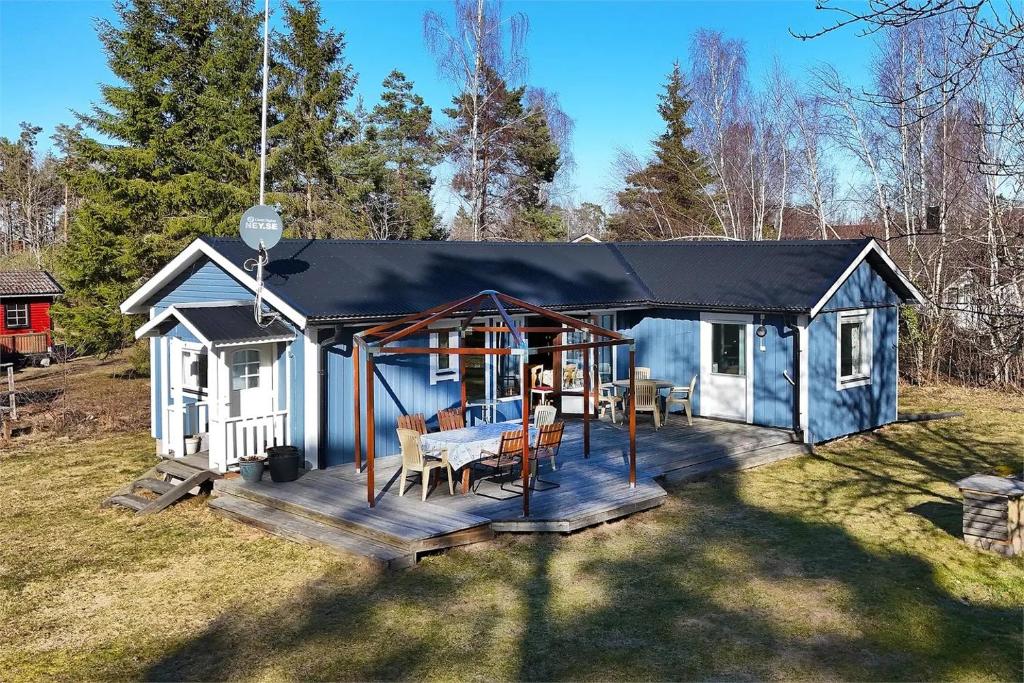 a blue and white shed with a table on a deck at Smaland Trollsjö in Mönsterås