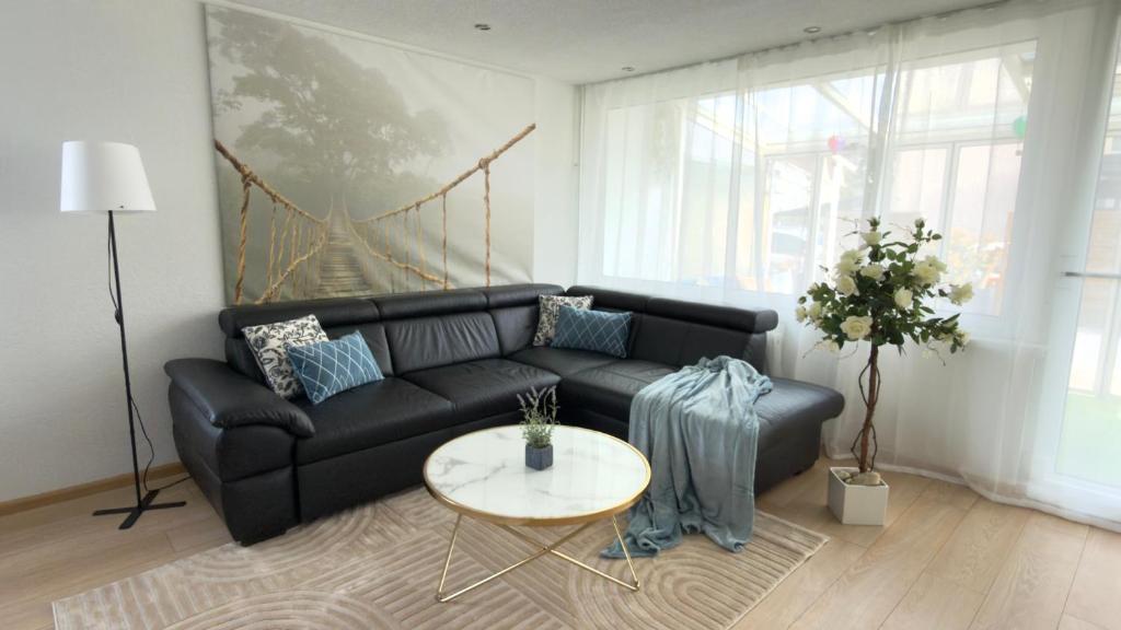 a living room with a black couch and a table at Basel Haven in Münchenstein
