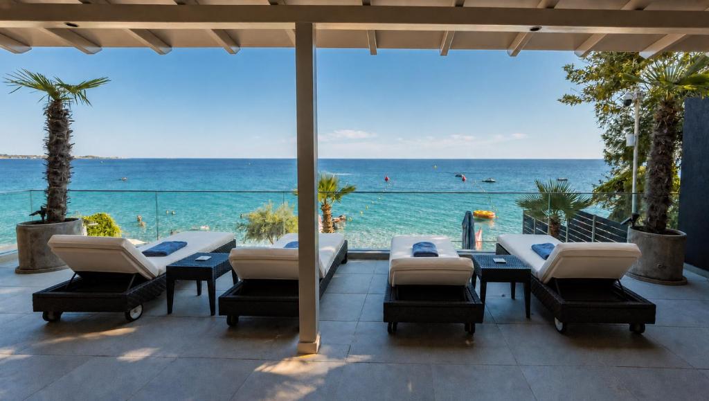 a patio with a table and chairs and the ocean at Infinity Beach House by KLV in Argostoli