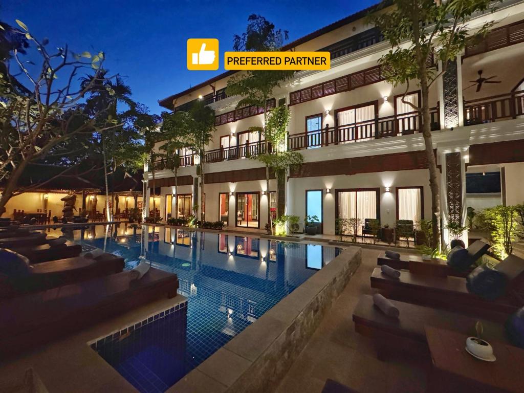 a hotel with a swimming pool in front of a building at Emerald Angkor Siem Reap in Siem Reap