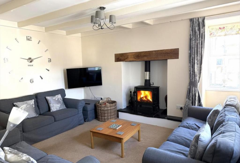 a living room with a couch and a fireplace at White Lion Aberporth in Aberporth