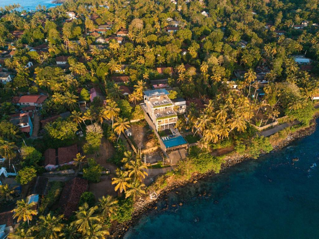 an aerial view of a house on an island with palm trees at Tombolo Bay in Dickwella