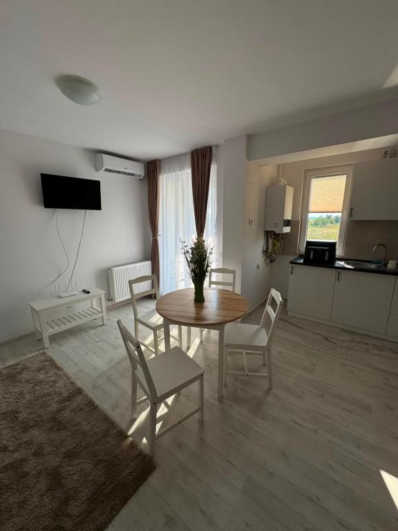 a living room with a table and chairs and a kitchen at Beside Gardens in Otopeni