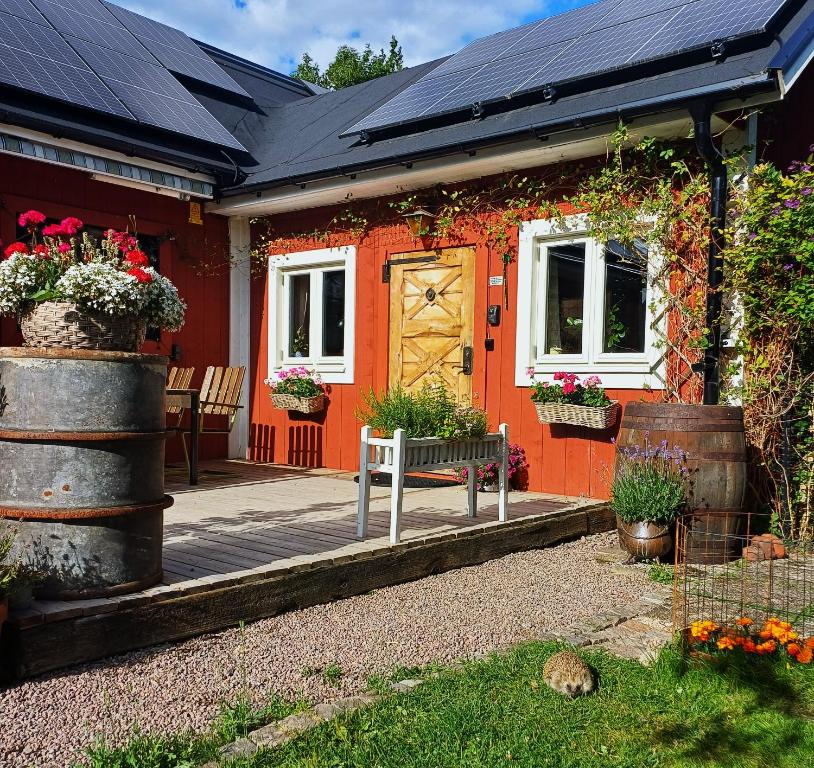 a red house with a porch with flowers on it at Villagatan in Hjo