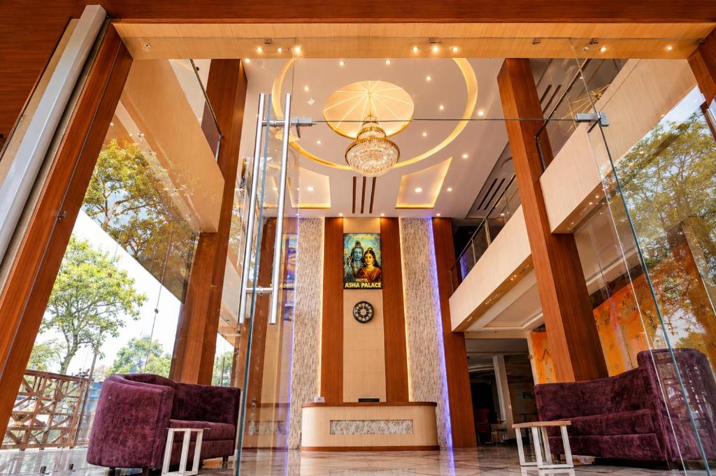 a lobby with two chairs and a chandelier at Hotel Asha Palace By Basotel in Deoghar