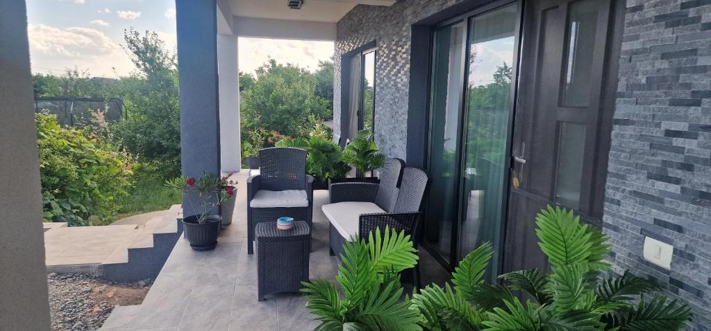 a patio with chairs and plants on a house at Villa Eliada in Tuzla