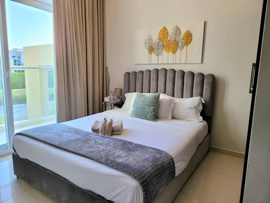 a bedroom with a large bed with a large window at Damac Hills 2 Villa Pool Front + Waterpark Access in ‘Ūd al Bayḑāʼ