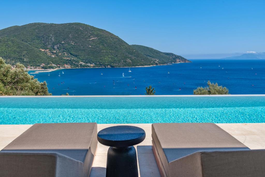 a view of a swimming pool with a stool in front at Deciel Cave Villa in Áyios Pétros