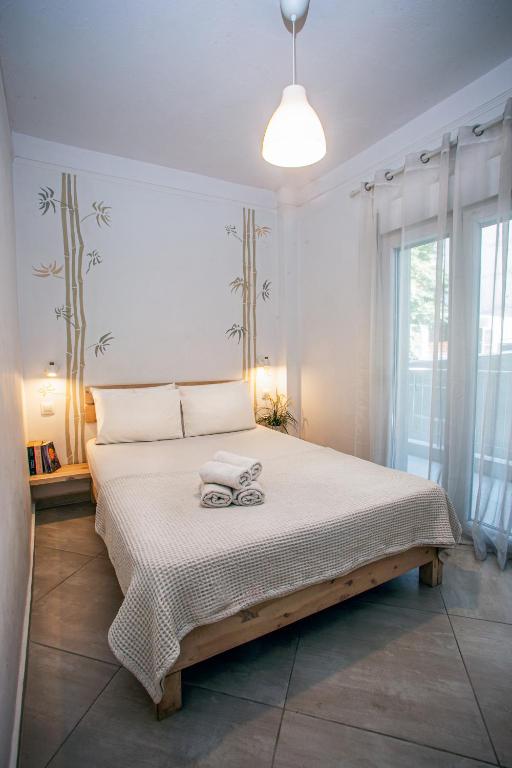 a bedroom with a large bed with a large window at Anastasios' artwork apartment in Thessaloniki