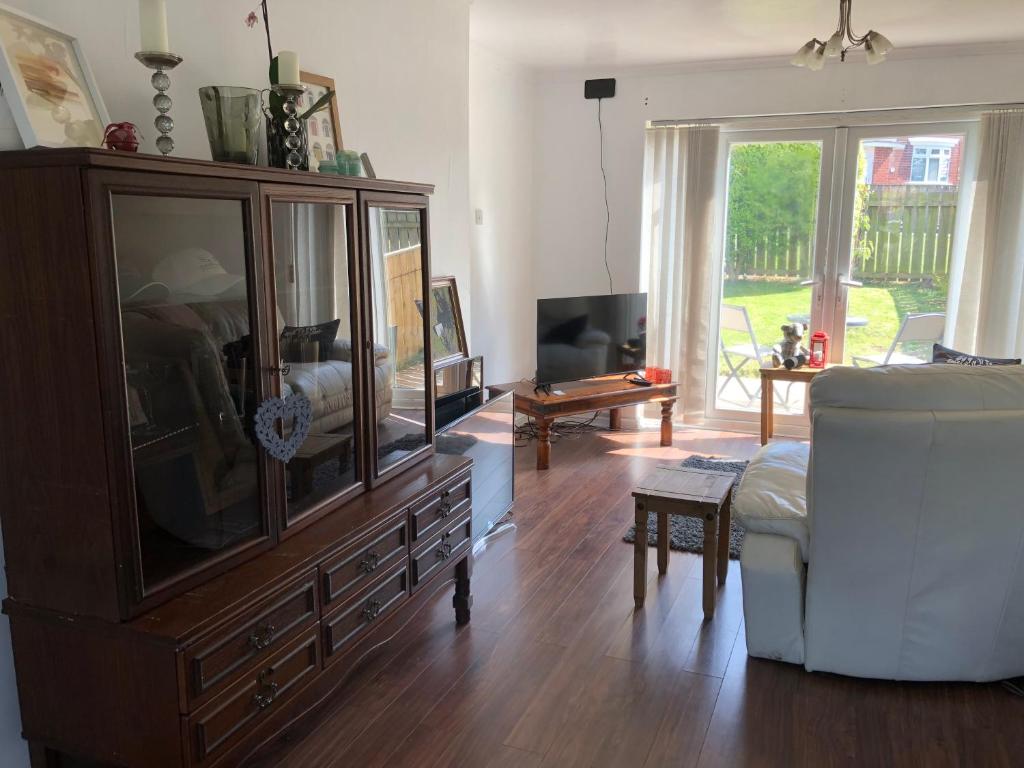 a living room with a large wooden entertainment center at Koti in Murton