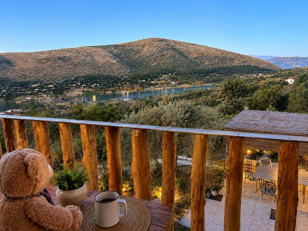 a teddy bear sitting on a table on a balcony at Villa Monte Shpirag in Berat