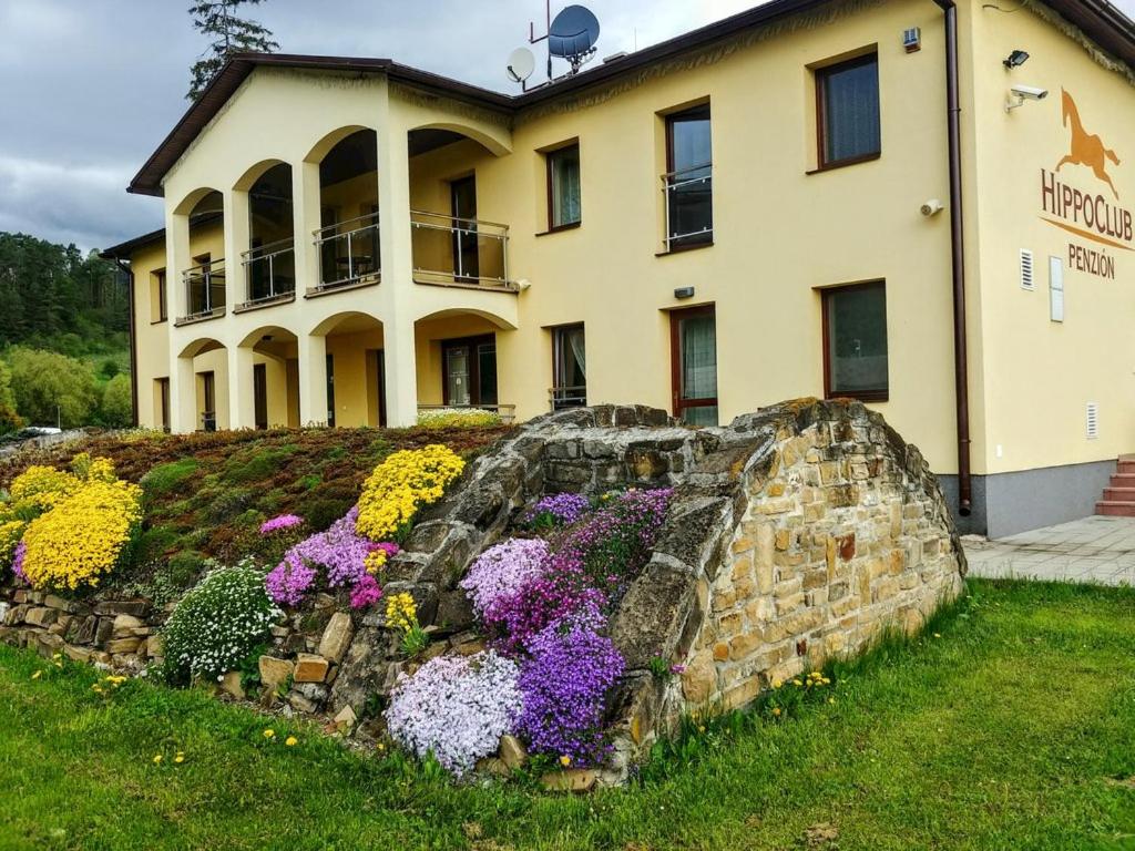 a building with a bunch of flowers in front of it at Wellness Villa Liptov in Žiar