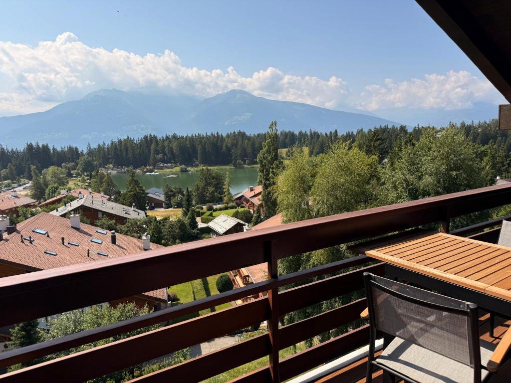 a view from the balcony of a resort with a lake and mountains at Attique de la Moubra 4 in Crans-Montana