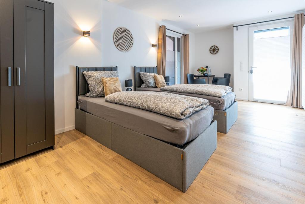 two beds in a room with wooden floors at Ferienwohnung 3 Gasthaus Bußmann in Vreden