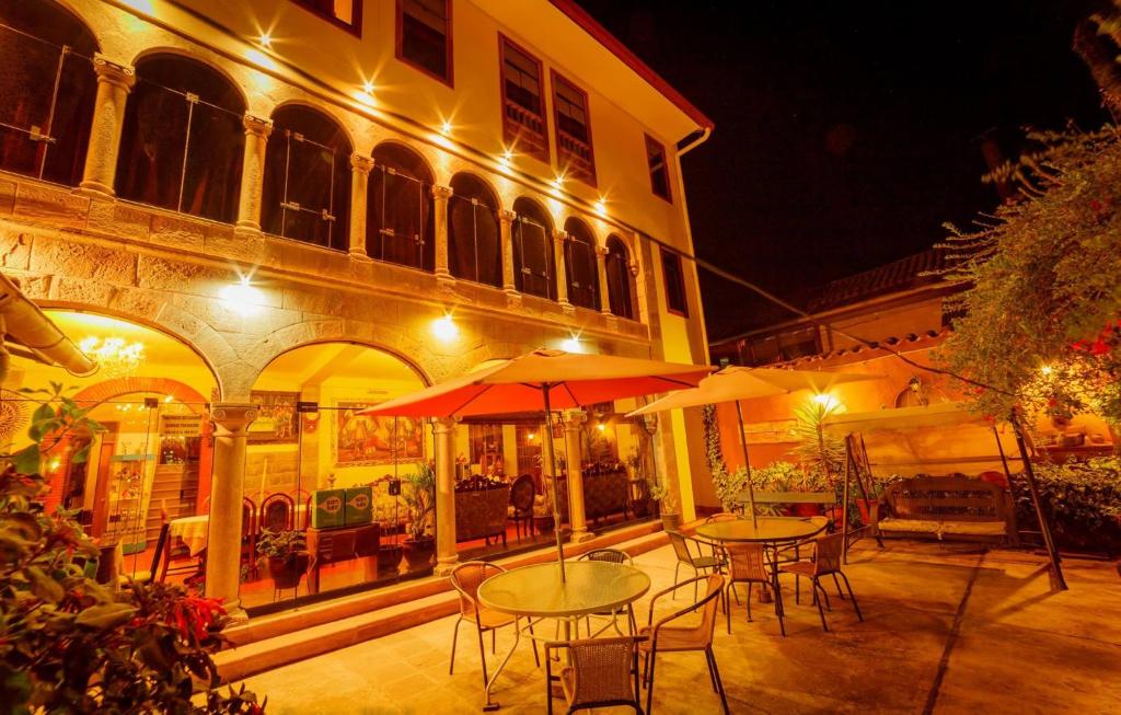 an outdoor patio with tables and umbrellas at night at Fuente de Agua in Cusco