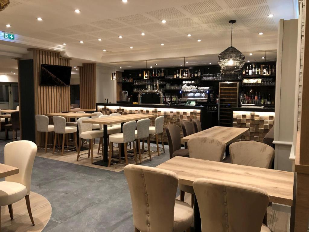 a restaurant with tables and chairs and a bar at Best Western Le Duguesclin Hôtel-Restaurant in Saint-Brieuc
