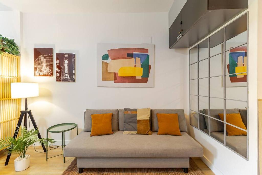 a living room with a couch and paintings on the wall at Studio Europa 30 in San Sebastián de los Reyes