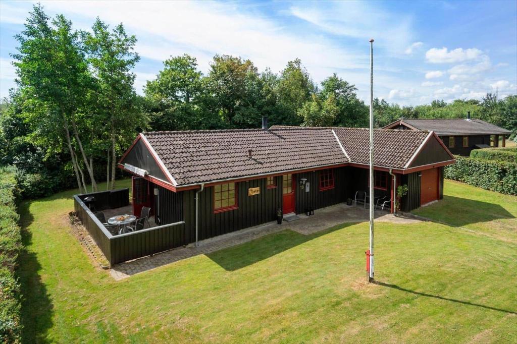 a small house in a yard with a grass yard at LF12118-Vinderup-Vigen-18 in Handbjerg