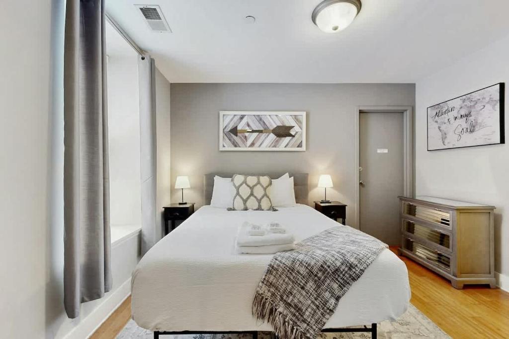 a bedroom with a large white bed and two lamps at Polk 401 in Nashville