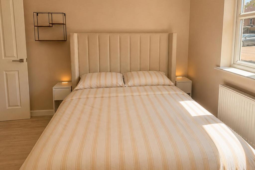 ein Bett in einem Schlafzimmer mit zwei Lampen auf zwei Tischen in der Unterkunft Bright, Spacious Double Room in a Modern Flat in Edmonton
