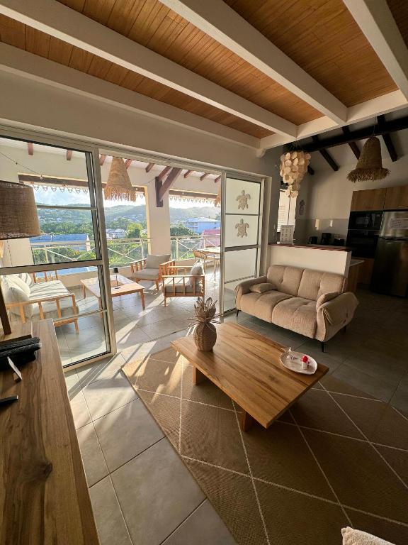 a living room with a couch and a table at Évasion Tropicale - vue et plage à 2 min in Les Trois-Îlets