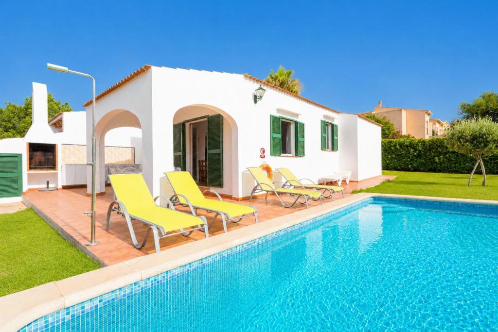 a villa with a swimming pool in front of a house at Villa Gelabert Ametller in Cala en Bosc