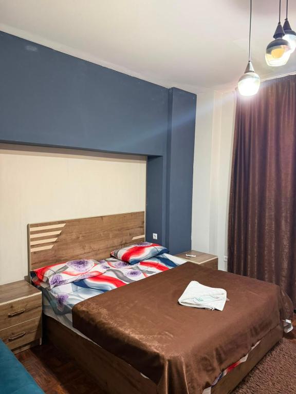 a bedroom with a bed and a blue wall at D&A hotel in Yerevan