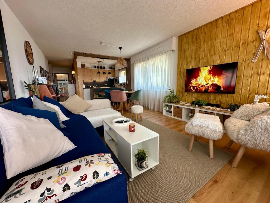 a living room with a blue couch and a fireplace at Appartement de vacances - ski-in ski-out in Veysonnaz