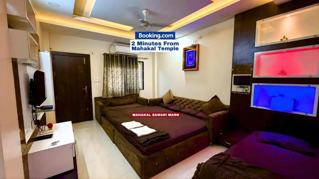 a living room with a couch and a flat screen tv at Shree Vaishnav Yatri Grah Near Mahakaleshwar Temple in Ujjain