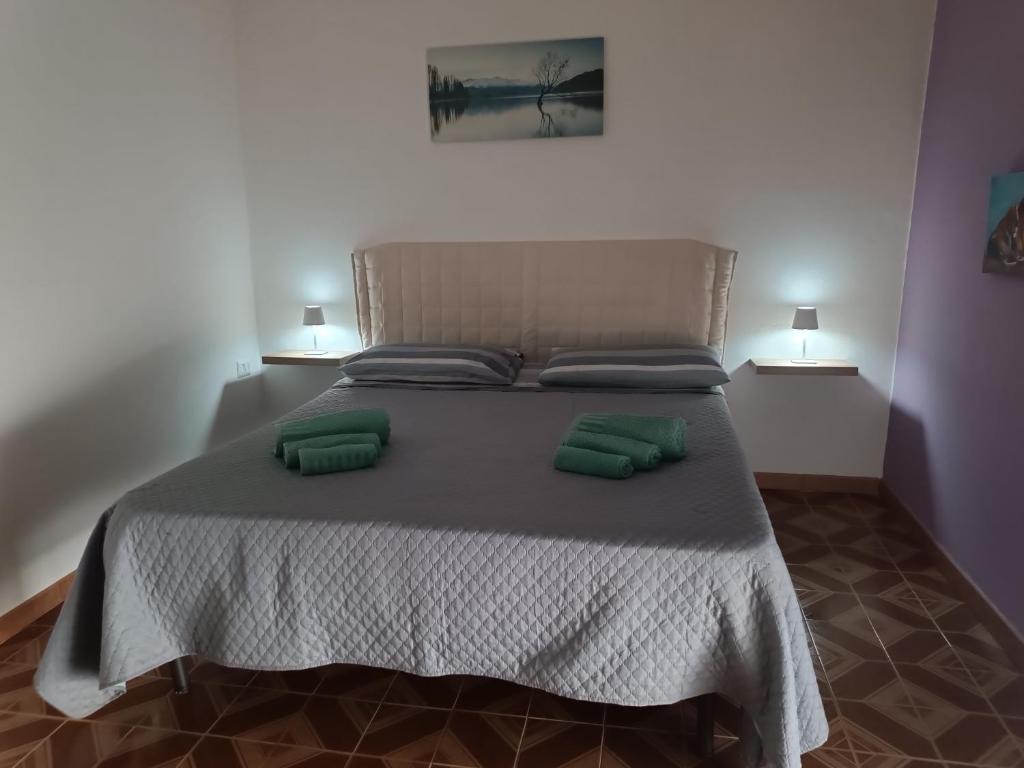 a large bed with two green pillows on it at Azzurra Haven in Berchidda
