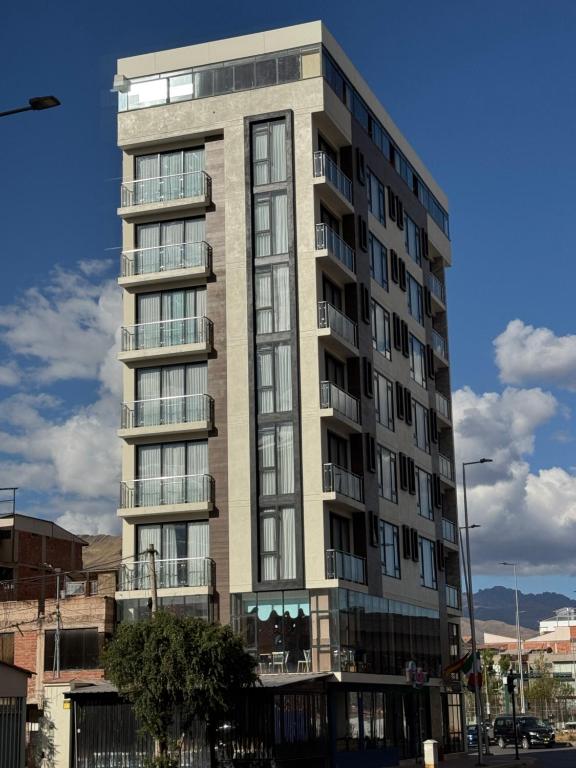 a tall apartment building with windows on a street at Hotel San Miguel Cusco in Cusco