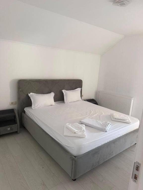 a bed in a room with two dishes on it at AME Home Apartament 2 in Ocna-Mureşului