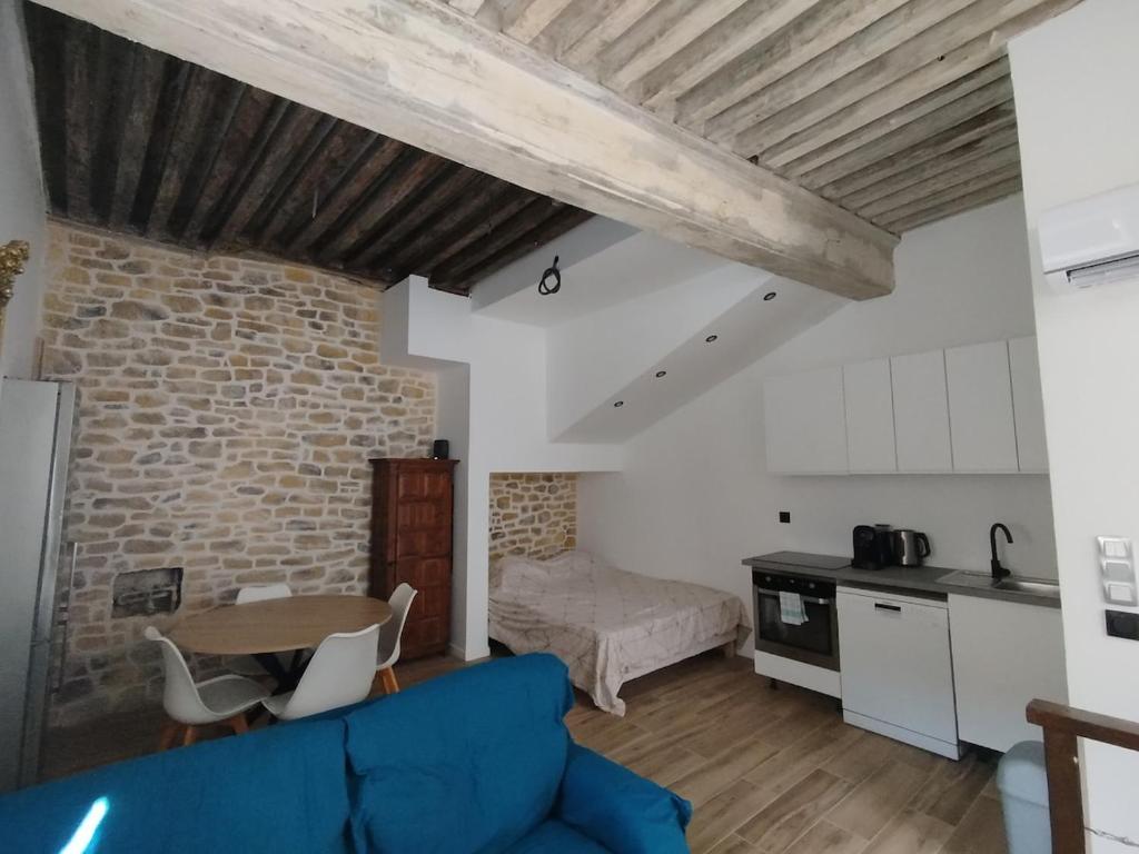 a living room with a blue couch and a kitchen at Trévoux centre appartement climatisé in Trévoux