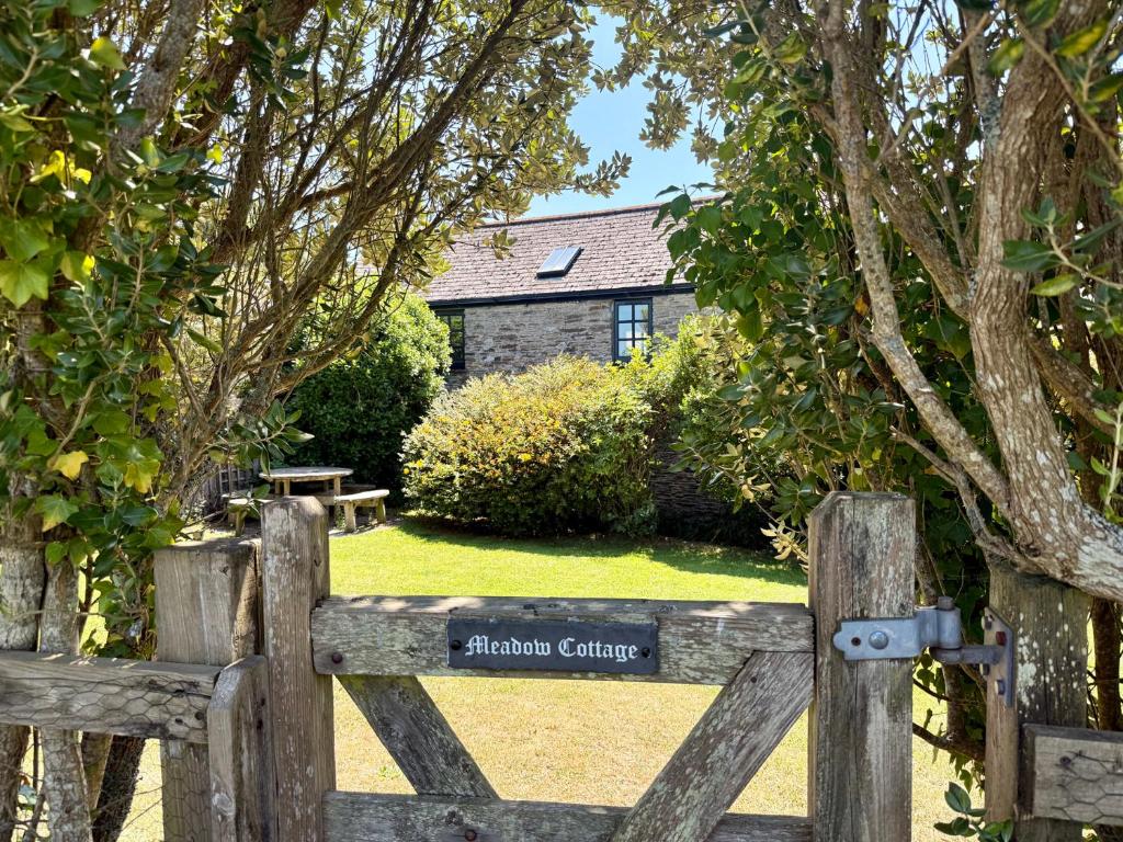 a wooden gate to a garden with a house at Meadow Cottage in Fowey