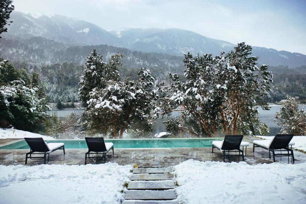 a group of chairs in the snow next to a pool at Auria Angostura in Villa La Angostura
