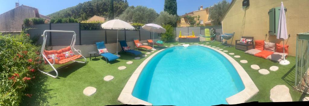 a backyard with a swimming pool with chairs and tables at Les Provences Bleu et Verte in Solliès-Pont