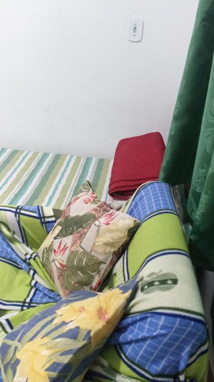 a bed with colorful sheets and pillows on it at Dormitório portal in Domingos Martins
