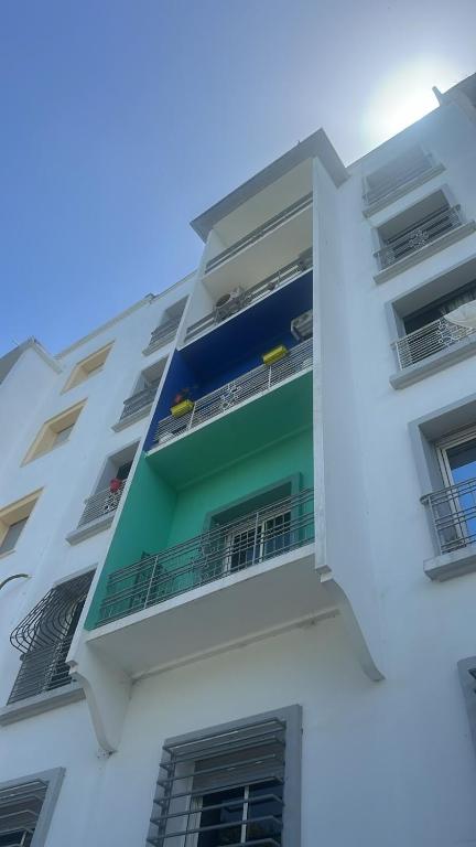 a white building with balconies on the side of it at Le coin vert in Rabat