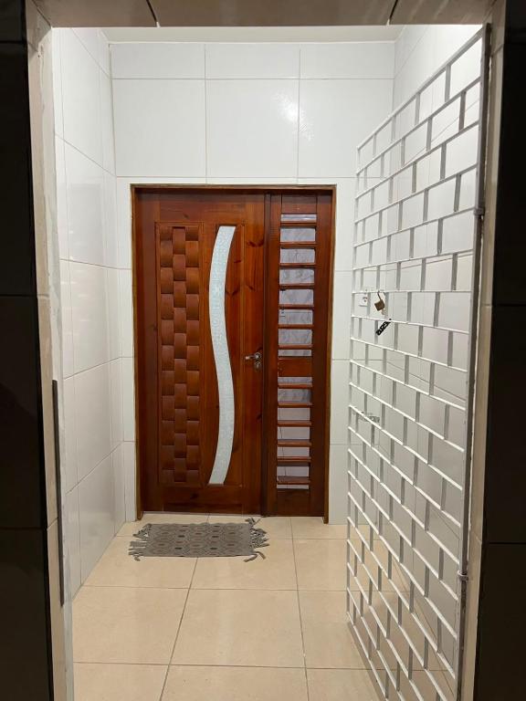 a bathroom with a wooden door and a tile hallway at Villa do mar Praia de Iracema in Fortaleza