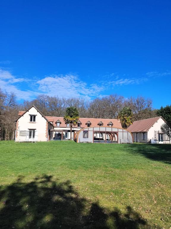 a large white house with a large grass field at Domaine Sylvaria in Lassay-sur-Croisne