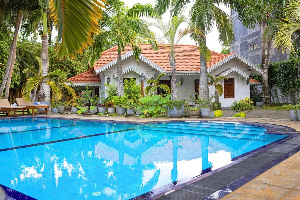a villa with a swimming pool in front of a house at Sisikirana Villa (Luxury Villa in Galle) in Unawatuna