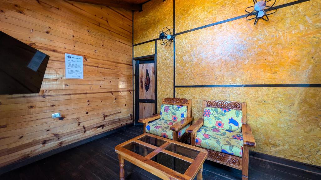 a room with two chairs and a ceiling fan at Embellupe Breakfast included in San Jose del Pacifico