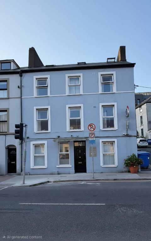 a white building on the corner of a street at Shamrock Quay in Cork