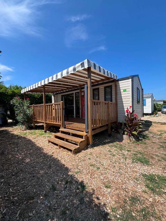 a small house with a porch and a deck at Camping Oléron Cap Soleil MH Climatisé in Saint-Denis-dʼOléron