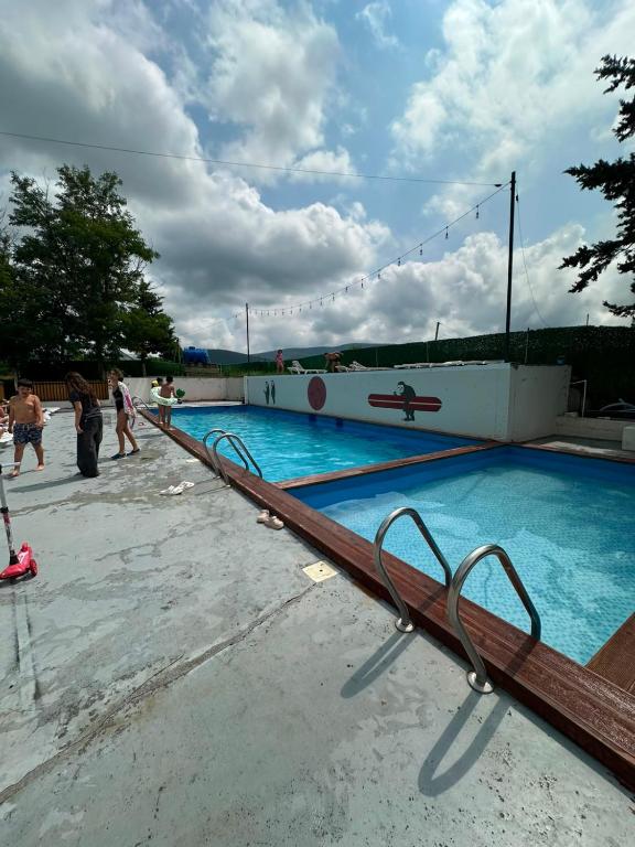an empty swimming pool with people walking around it at Bazaleti Lake Family Apartment in Chanadirtkari