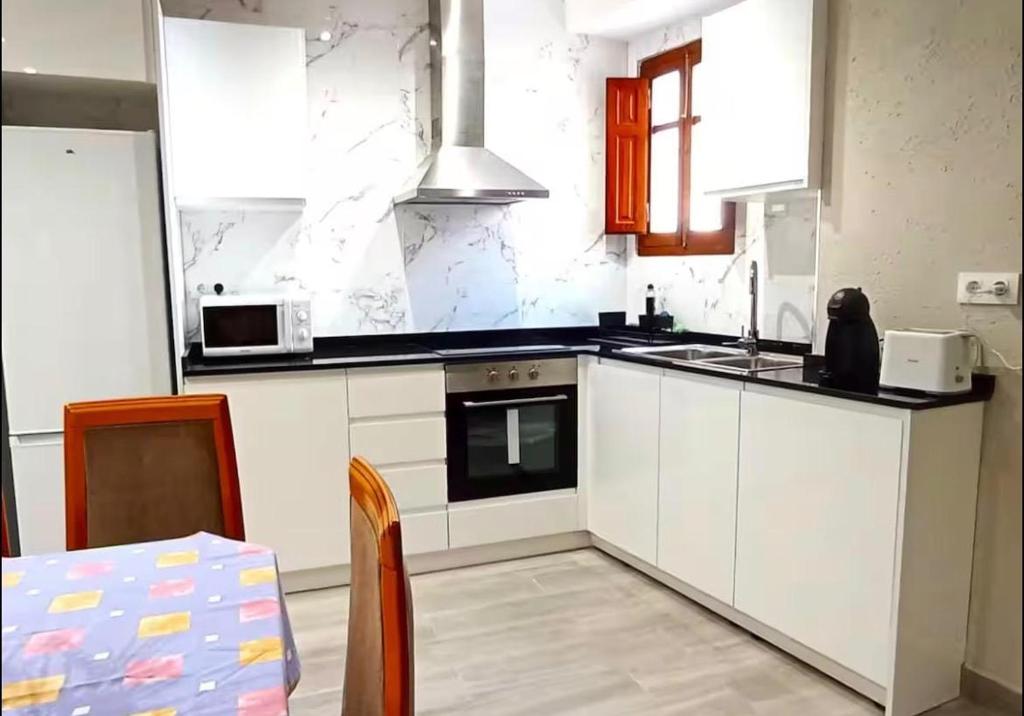 a kitchen with white cabinets and a stove top oven at Casa reformada centro de Lliria in Lliria
