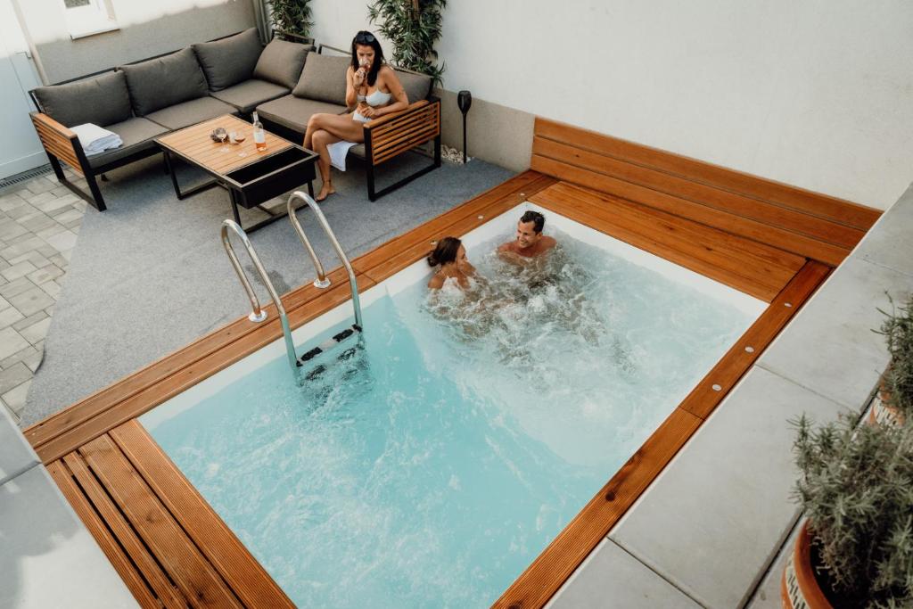 two people in a swimming pool in a house at Wellness apartmán Habánská in Pouzdřany
